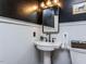 Powder room featuring pedestal sink, bronze fixtures, and black accent wall with wainscotting at 3332 Langston Cir, Apex, NC 27539