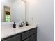 Bathroom vanity with a dark base, white countertop, modern faucet, mirror, and a green plant at 3332 Langston Cir, Apex, NC 27539