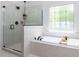 Bathroom with a glass enclosed shower and garden tub with black fixtures at 3332 Langston Cir, Apex, NC 27539