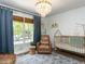Bright Bedroom with a large window, stylish light fixture, crib, plush chair, and patterned rug at 3332 Langston Cir, Apex, NC 27539