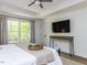 Bedroom with large window views, tray ceiling, and an entertainment console at 3332 Langston Cir, Apex, NC 27539