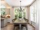 Bright dining room with natural light from multiple windows and chandelier above long wooden table at 3332 Langston Cir, Apex, NC 27539