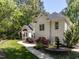 Beautiful white brick home surrounded by mature trees and a decorative fountain at 3332 Langston Cir, Apex, NC 27539