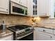 View of gourmet kitchen featuring tile backsplash, stainless steel appliances, and granite countertops at 3332 Langston Cir, Apex, NC 27539