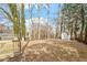 Large fenced backyard with mature trees and a wooden shed, offering privacy and space at 3408 Brentwood Rd, Raleigh, NC 27604