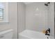 Bathroom featuring tiled shower over tub and a window offering natural light at 3408 Brentwood Rd, Raleigh, NC 27604