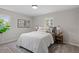 Bedroom featuring large windows, wood floors, neutral color scheme, and artwork at 3408 Brentwood Rd, Raleigh, NC 27604