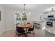Bright dining area featuring modern light fixture, table set and view to kitchen with bar seating at 3408 Brentwood Rd, Raleigh, NC 27604