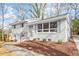 Exterior of freshly painted white home with manicured lawn, shutters, brick, and mature trees at 3408 Brentwood Rd, Raleigh, NC 27604