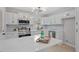 Modern kitchen with stainless steel appliances, a marble island, and bright white cabinets with contemporary lighting at 3408 Brentwood Rd, Raleigh, NC 27604