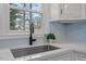 A close-up view of the kitchen sink, showcasing a modern faucet and bright window at 3408 Brentwood Rd, Raleigh, NC 27604