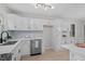 Bright kitchen with white cabinets, stainless steel appliances and wood flooring at 3408 Brentwood Rd, Raleigh, NC 27604