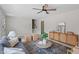 Neutral colored living room with ceiling fan, woven wood console, and gray sofa with textured pillows at 3408 Brentwood Rd, Raleigh, NC 27604