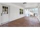 Enclosed porch with white brick wall and sliding glass windows at 3408 Brentwood Rd, Raleigh, NC 27604