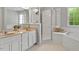 Bright bathroom with double sinks, a glass shower, and a soaking tub by the window at 4540 Mistiflower Dr, Raleigh, NC 27606