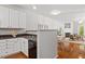 Open kitchen view featuring white cabinets, modern appliances, and an open view into the adjacent living area at 4540 Mistiflower Dr, Raleigh, NC 27606