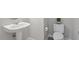 A clean half bathroom featuring a pedestal sink, toilet, and tiled floor at 4540 Mistiflower Dr, Raleigh, NC 27606