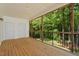 Inviting screened porch with wood flooring, two doors, and views of the wooded yard at 4540 Mistiflower Dr, Raleigh, NC 27606