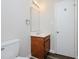 Bathroom featuring toilet and sink with wood vanity and large mirror at 4602 Millstone Dr # C, Raleigh, NC 27604
