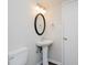 Bathroom featuring toilet and pedestal sink with decorative oval mirror above sink at 4602 Millstone Dr # C, Raleigh, NC 27604