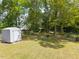 A well-maintained backyard with lush green grass, a storage shed and mature trees, providing a serene outdoor space at 4908 Vallery Pl, Raleigh, NC 27604