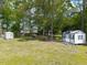 Well-maintained backyard with lush green grass, storage shed and mature trees, perfect for outdoor activities at 4908 Vallery Pl, Raleigh, NC 27604