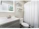 Bathroom featuring gray vanity with white sink, toilet, and tiled shower with curtain at 4908 Vallery Pl, Raleigh, NC 27604