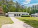 Charming single story house with attached garage, front yard, and mature trees in background at 4908 Vallery Pl, Raleigh, NC 27604