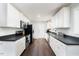 Kitchen with stainless steel appliances, white cabinets, and dark countertops at 4908 Vallery Pl, Raleigh, NC 27604