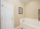 Bathroom featuring a soaking tub next to a white door with a tile floor at 5026 Celtic Ct, Raleigh, NC 27612