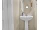 Cozy powder room featuring a pedestal sink, oval mirror, and fresh design, located on the main floor at 503 Bellefont Ct, Knightdale, NC 27545