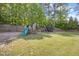 Fenced backyard features a play set with a slide and a trampoline for outdoor entertainment at 503 Mugo Pine Ct, Wendell, NC 27591