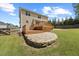 Spacious backyard with a wooden deck, stone patio, and lush green lawn at 503 Mugo Pine Ct, Wendell, NC 27591