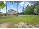 Large backyard with lush green grass, featuring a wooden deck, play-set, and perimeter privacy fence at 503 Mugo Pine Ct, Wendell, NC 27591