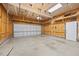Spacious garage with unfinished walls, exposed ceiling beams and a roll up garage door at 503 Mugo Pine Ct, Wendell, NC 27591