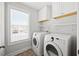 Laundry room with side-by-side washer and dryer, overhead cabinets, and a window at 503 Mugo Pine Ct, Wendell, NC 27591