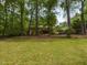 Spacious backyard featuring lush green lawn and mature trees providing ample shade and privacy for relaxation at 508 Colony Woods Dr, Chapel Hill, NC 27517