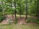 Secluded backyard with garden beds, stone path, and mature trees offers a tranquil outdoor setting at 508 Colony Woods Dr, Chapel Hill, NC 27517