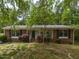 Charming brick home with a covered porch, complemented by mature trees and lovely landscaping at 508 Colony Woods Dr, Chapel Hill, NC 27517
