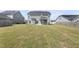 View of the home's backyard and exterior showing a well-manicured lawn and covered patio at 509 National Dr, Clayton, NC 27520