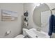 Cozy half bathroom with modern fixtures, decorative art, and storage baskets at 509 National Dr, Clayton, NC 27520