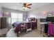 Bedroom featuring striped accent wall, ceiling fan, and window at 5204 Nautical Ln, Raleigh, NC 27610