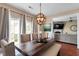 Bright dining room featuring a rustic wood table, upholstered chairs, and modern chandelier lighting at 5204 Nautical Ln, Raleigh, NC 27610