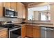 Well-equipped kitchen with stainless steel appliances, wood cabinets, and a view of the eating area at 5204 Nautical Ln, Raleigh, NC 27610