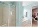 A bathtub and shower in a bathroom with blue walls and tile floors at 5204 Nautical Ln, Raleigh, NC 27610