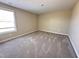 A simple bedroom features neutral walls, plush carpet, and natural light, creating a serene retreat at 56 Ruskin Dr, Smithfield, NC 27577