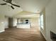 Open living area with a fireplace, ceiling fan, and hardwood floors with a view of the kitchen at 56 Ruskin Dr, Smithfield, NC 27577