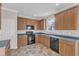 Well-lit kitchen features wood cabinets, black appliances, and durable tile flooring at 5609 Severn Grove Dr, Durham, NC 27703