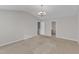 Bright, carpeted living room featuring a modern chandelier and two doors at 5609 Severn Grove Dr, Durham, NC 27703