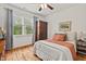Cozy bedroom featuring hardwood floors, a ceiling fan, and a large window offering natural light at 563 Great Ridge Parkway, Chapel Hill, NC 27516